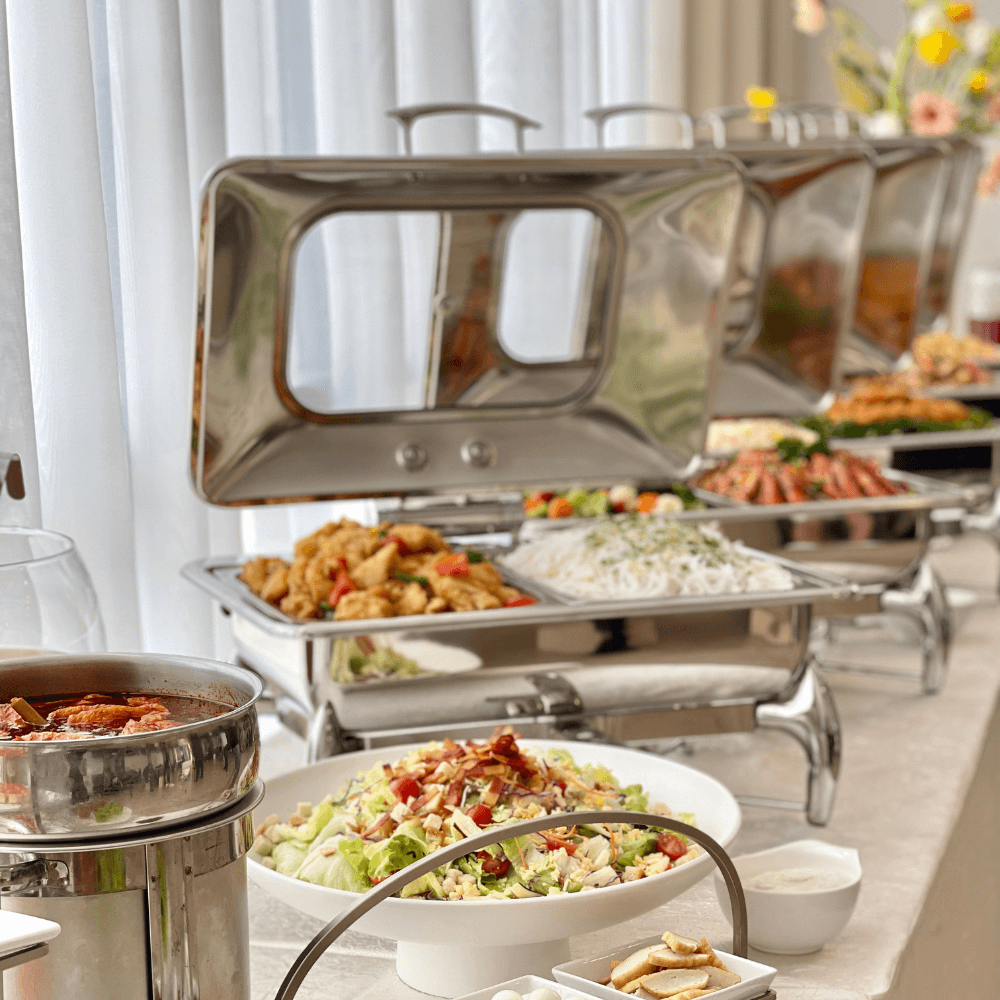 Lined up buffet warmers with assorted dishes on table