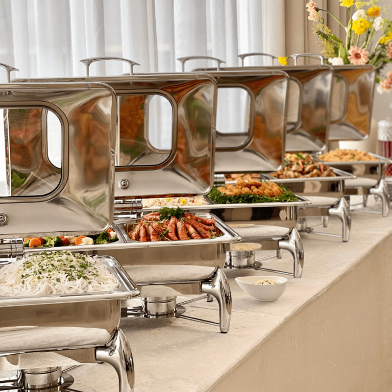Lined up buffet warmers with assorted dishes on table