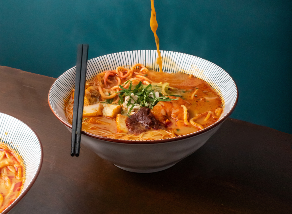 Halal Bento Catering | Laksa artistic shot pouring from spoon