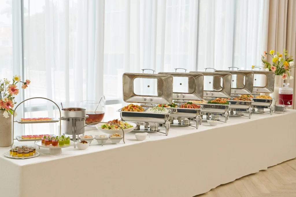buffet warmers lined up on a table with ivory cloth