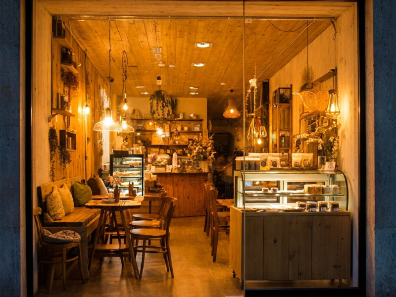 View through a window of a cozy cafe interior with warm lighting.